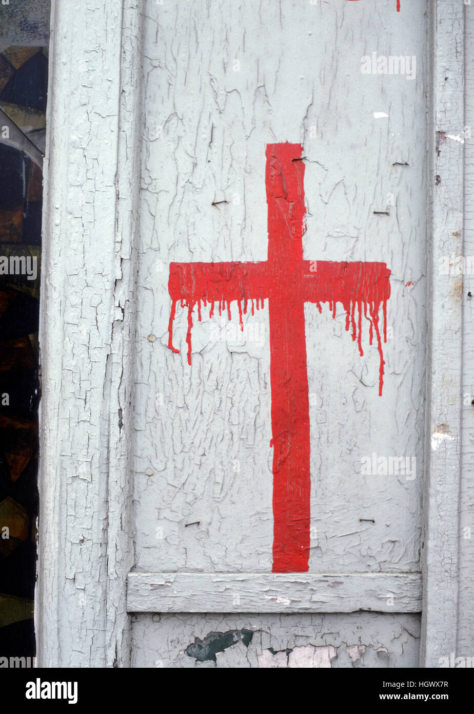 Red Cross painted beside the door of a storefront church Stock Photo
