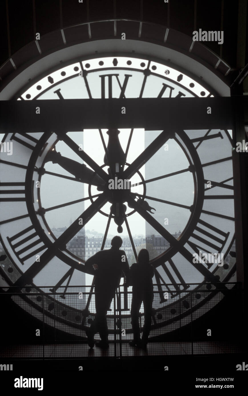 Couple behind the clock at the Orsay in Paris, France Stock Photo