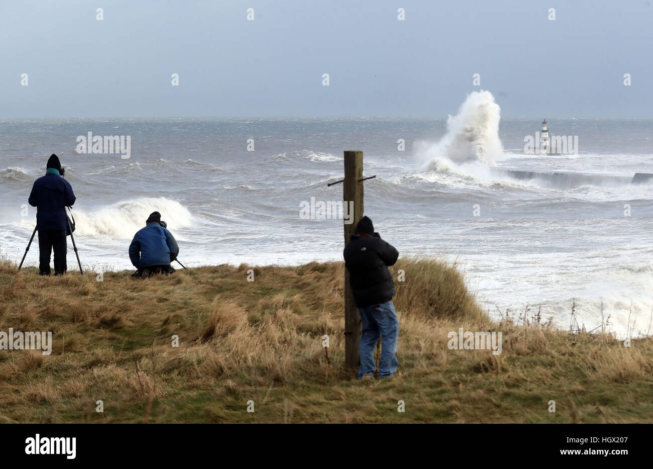 Locals photograph waves crashing into the sea wall at Seaham Harbour as Scotland and the North of England were covered in a blanket of snow while the east coast was braced for a storm surge at Friday lunchtime. Stock Photo