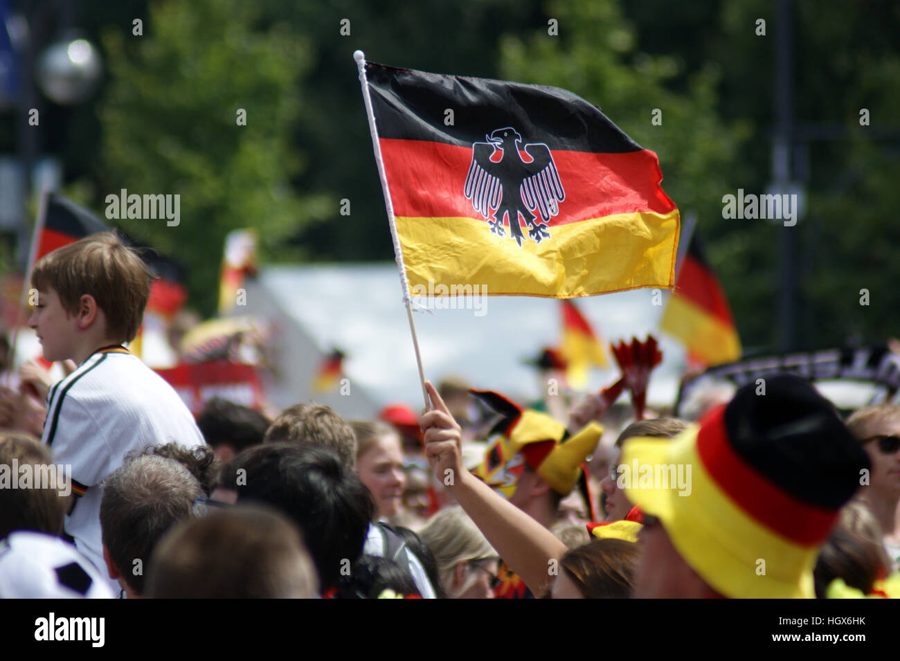 German flag being raised by a person in a crowd in Berlin, German that is celebrating the German win of the 2015 World Cup. Stock Photo