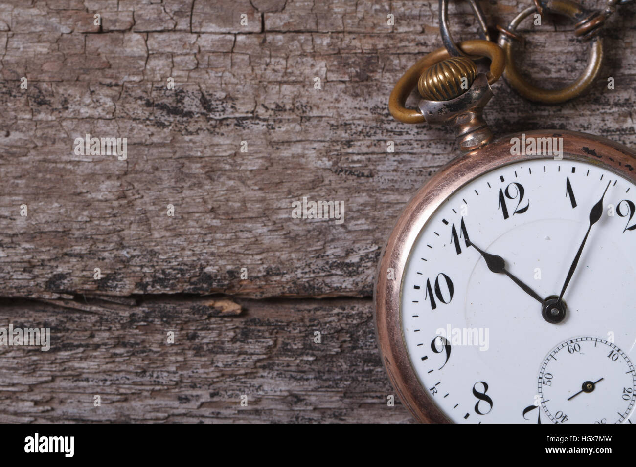 old pocket watch on a chain on an old wooden table closeup Stock Photo