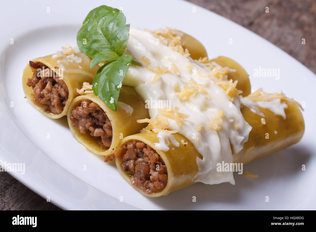 Cannelloni pasta stuffed with meat and bechamel sauce and basil on the  table Stock Photo - Alamy