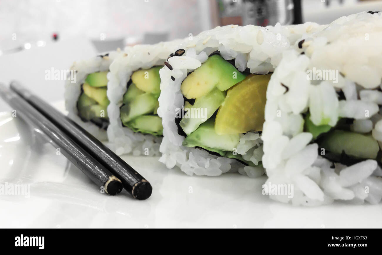 Japanese cuisine. Closeup of fresh veggie maki rolls with avocado. Stock Photo