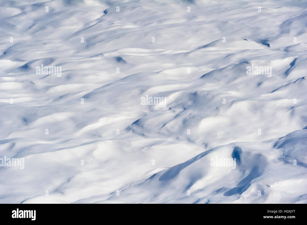 Layers of snow mask deep crevasse on the surface of the vast Greenland Ice Sheet plain. Stock Photo