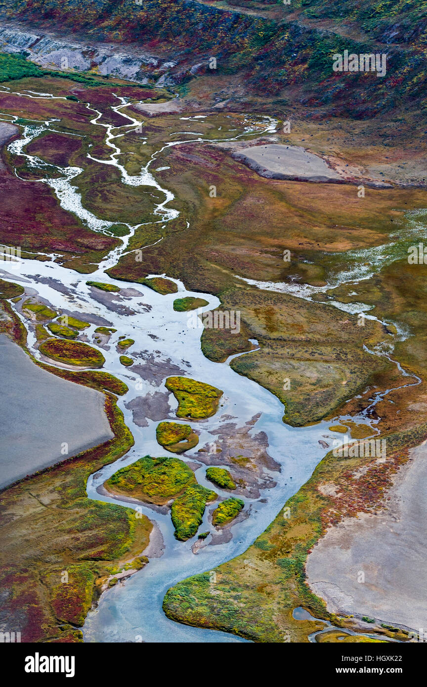 A winding river snakes it's way across a highland tundra valley floor ...