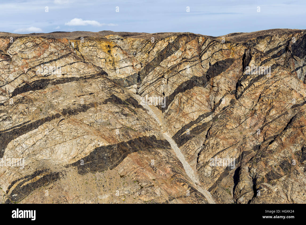 Folded layers of rock and pressure ridges in a cliff face. Stock Photo