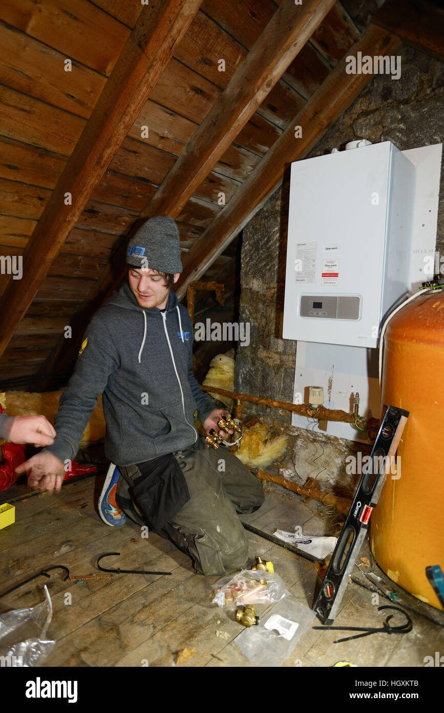 Plumbers fitting new boiler in a loft in an old house in Aberdeen Scotland  Stock Photo - Alamy