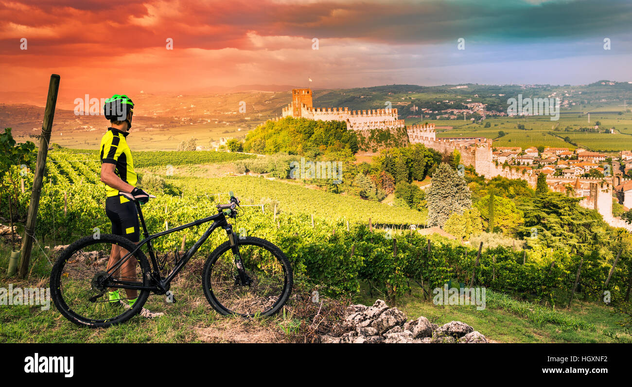 Cyclist admires from the hill the Soave castle views. Stock Photo