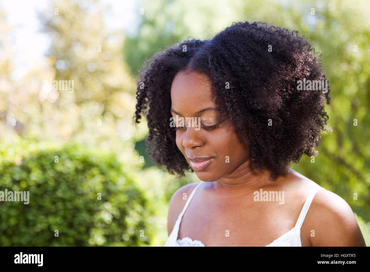 Confident African American woman outside in a garden Stock Photo - Alamy