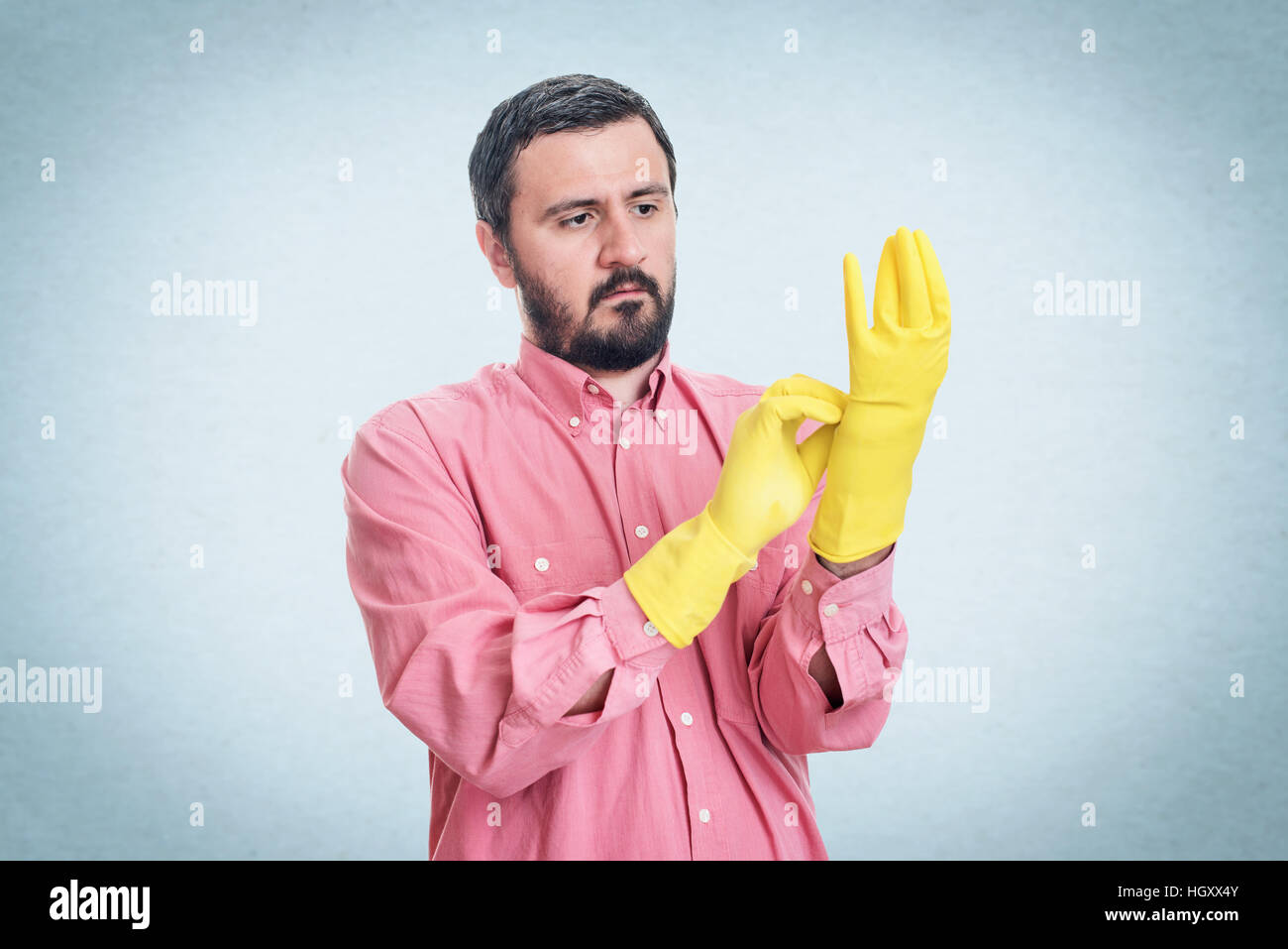 Cleaning man putting latex glove and prepare to clean house isolated on