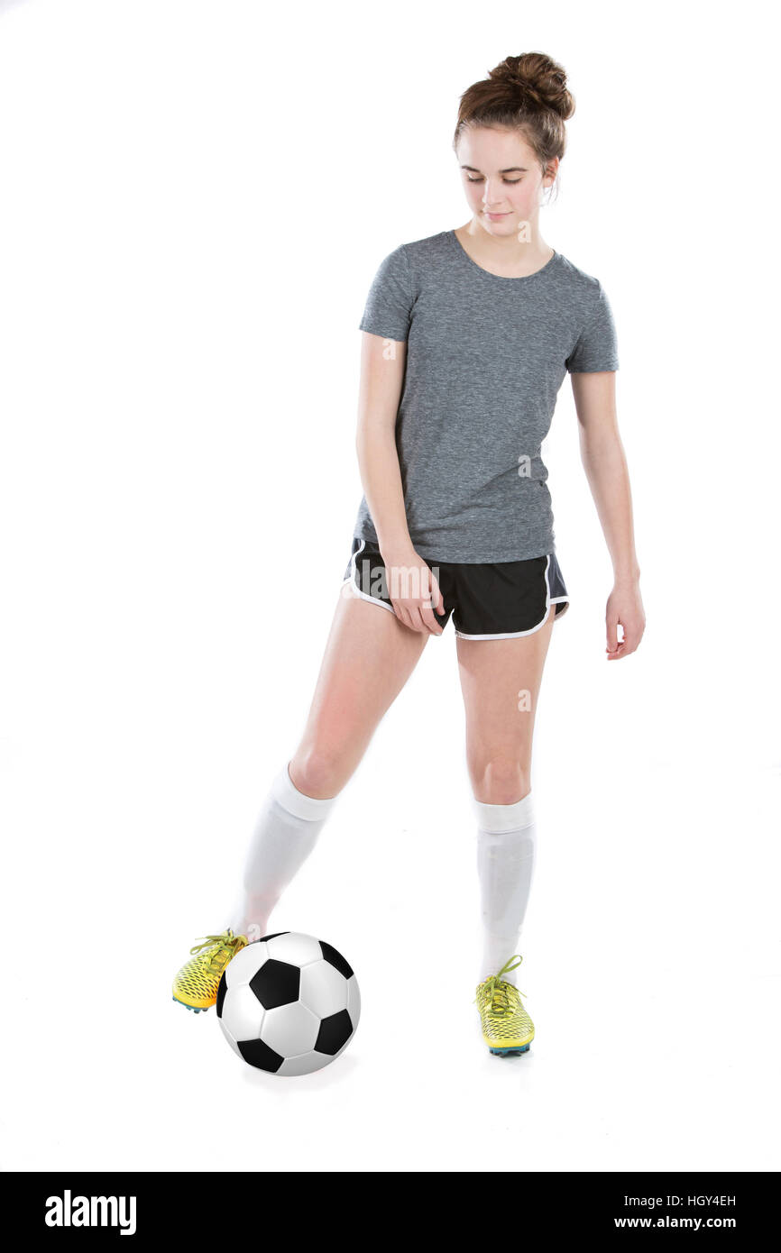 Teenage girl wearing soccer cleats and shin guards playing with a soccer ball between her feet.  Concept for school sports or teen sports. Stock Photo