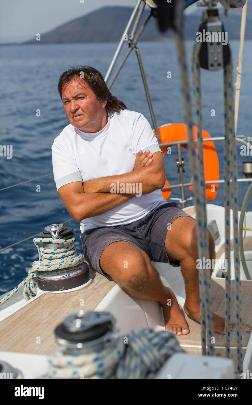 A man sits aboard his sailing yacht Stock Photo - Alamy