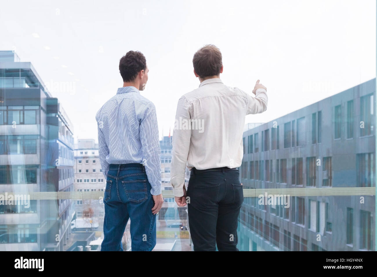 Two business people talking and looking at the horizon, one person pointing at something. Concept about projects, visions, opportunities Stock Photo