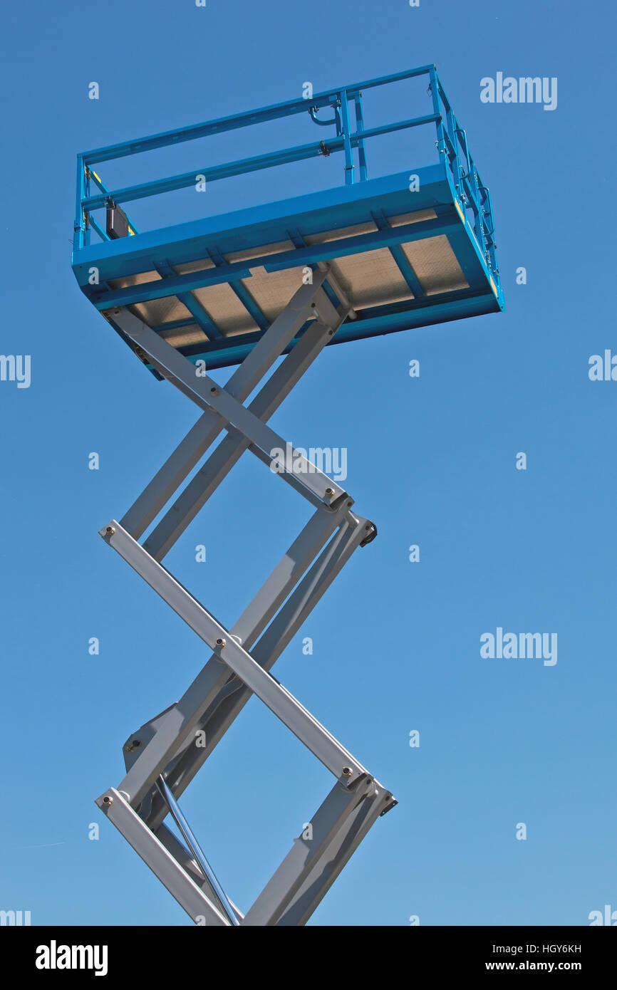 Blue scissor lift platform against clear sky Stock Photo - Alamy