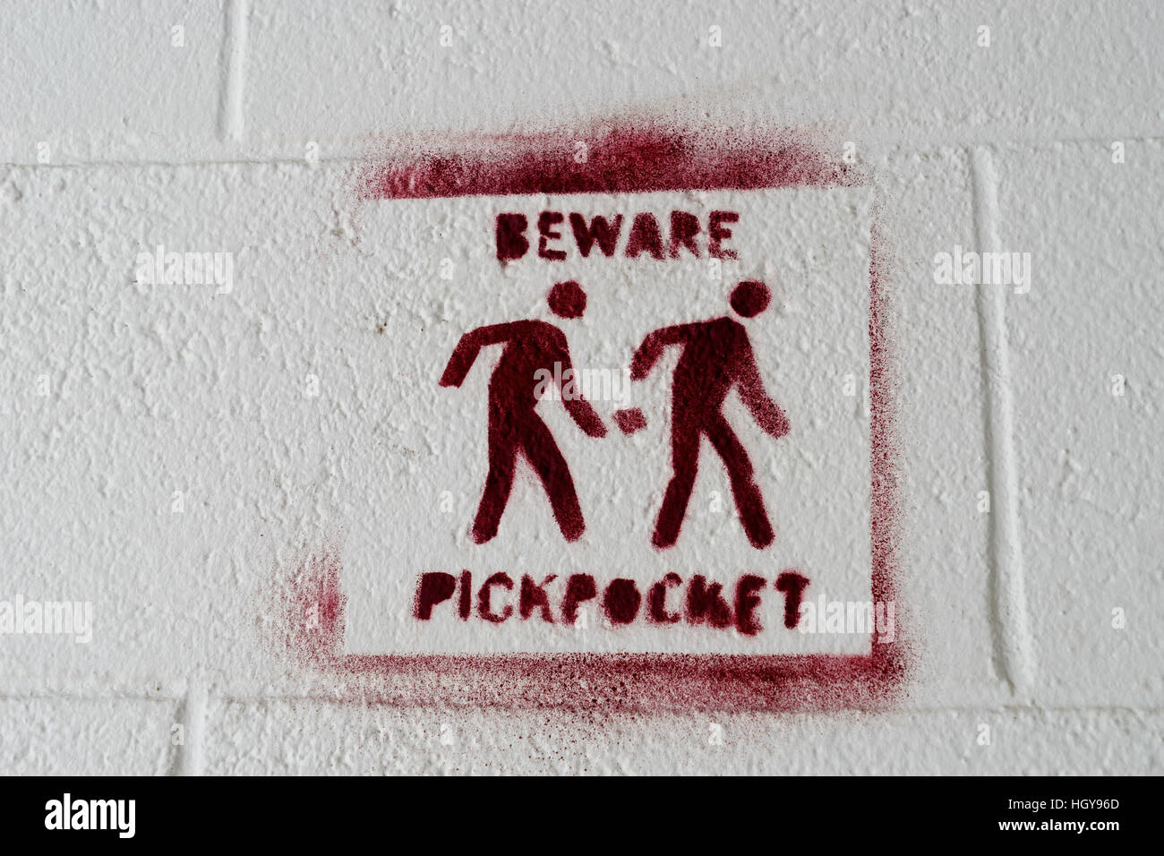 Pickpocket warning sign stencilled on to a white wall Stock Photo