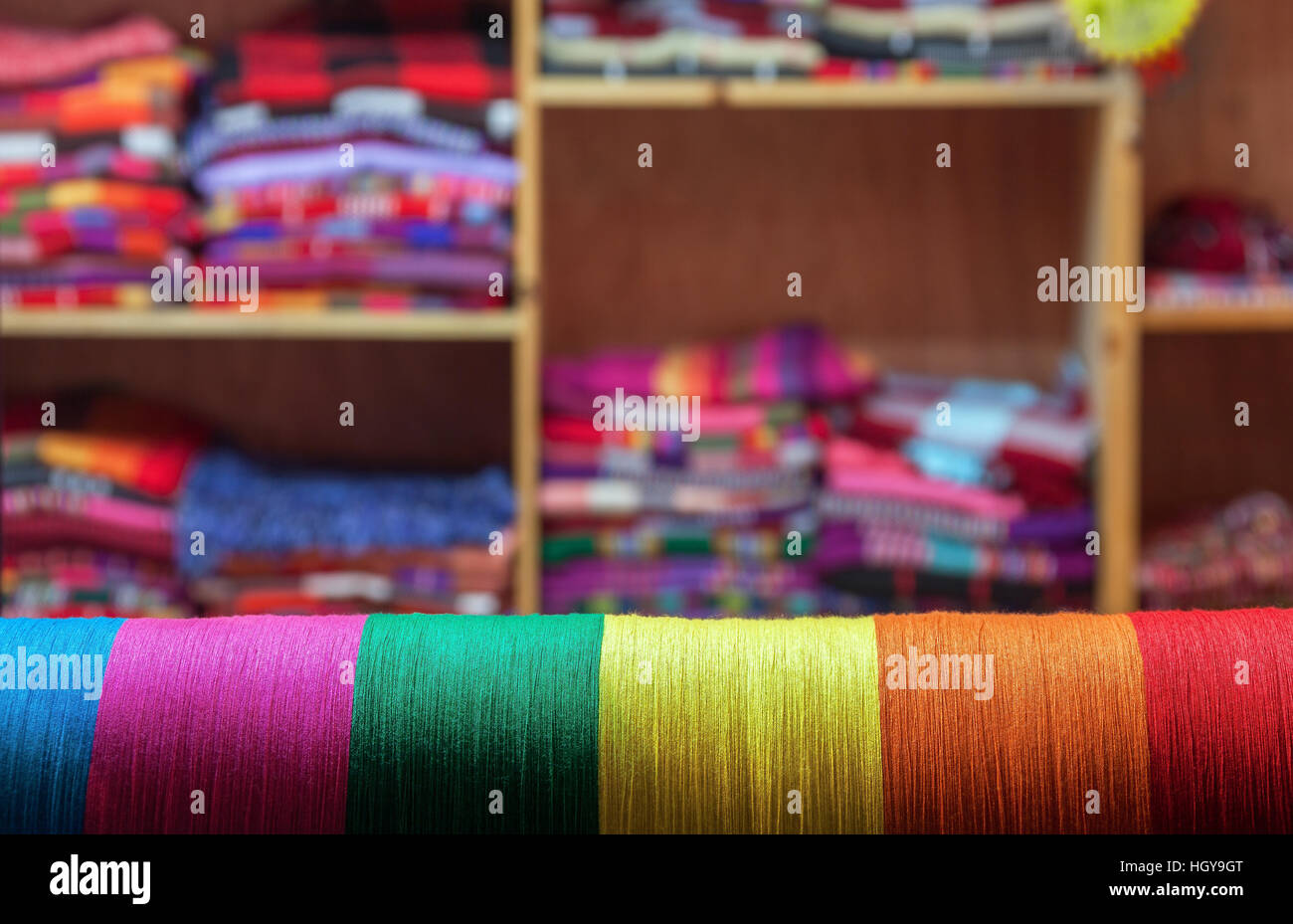 Colored threads on a background of the finished products, tailoring concept. Stock Photo