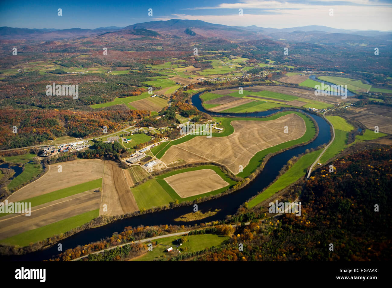 The Connecticut River flows through farmland in Newbury, Vermont and Haverhill, New Hampshire.  Mount Moosilaukee is in the distance. Aerial. Stock Photo