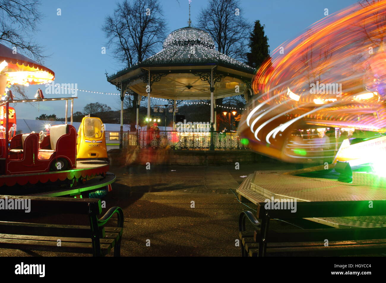 Funfair rides by the decorated bandstand in Hall Leys Park in Matlock a pretty Derbyshire market town, England UK - December Stock Photo
