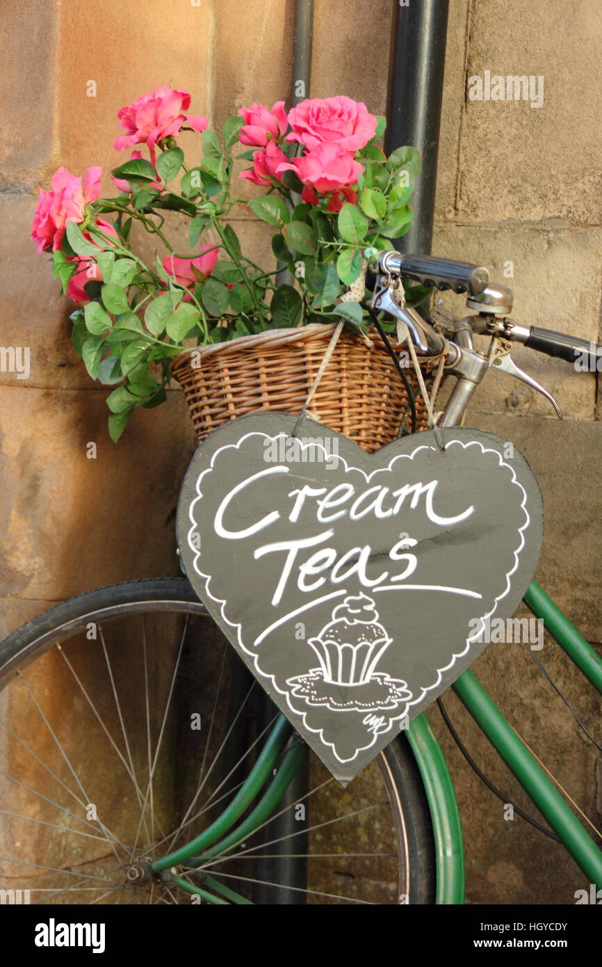 Cream teas. Vintage bicycle displaying florals and a sign for cream tea outside an English tea room, England UK Stock Photo