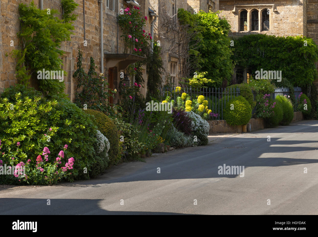 Cotswold stone cottages with colourful roadside floral borders in the village of Stanton, Cotswolds, Gloucestershire, England Stock Photo