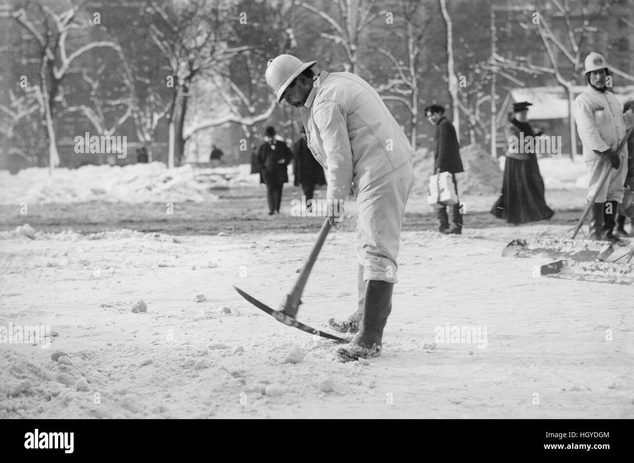 Man Clearing Snow from Street with Pickaxe, New York City, New York, USA, Bain News Service, January 1908 Stock Photo