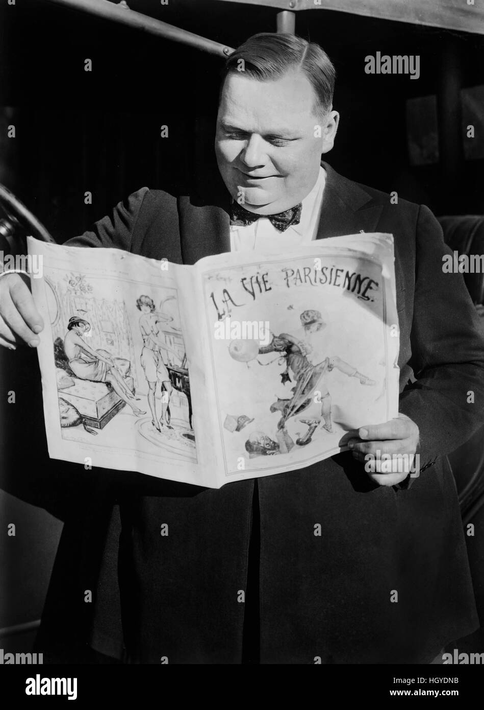 American Actor, Roscoe 'Fatty' Arbuckle, Portrait Reading French Newspaper, La Vie Parisienne, Bain New Service, 1921 Stock Photo
