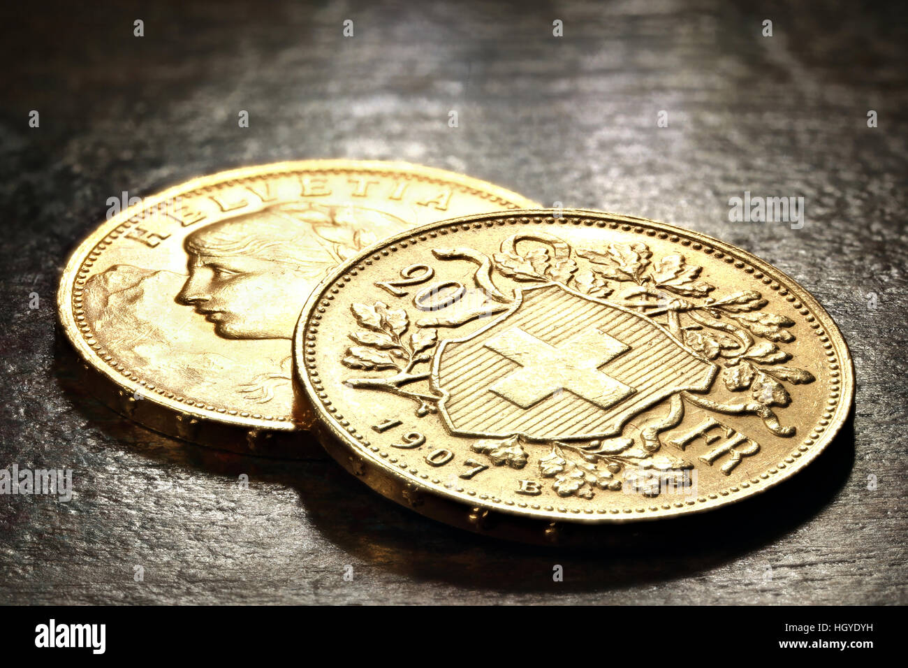 Swiss Vreneli gold coins on rustic wooden background Stock Photo