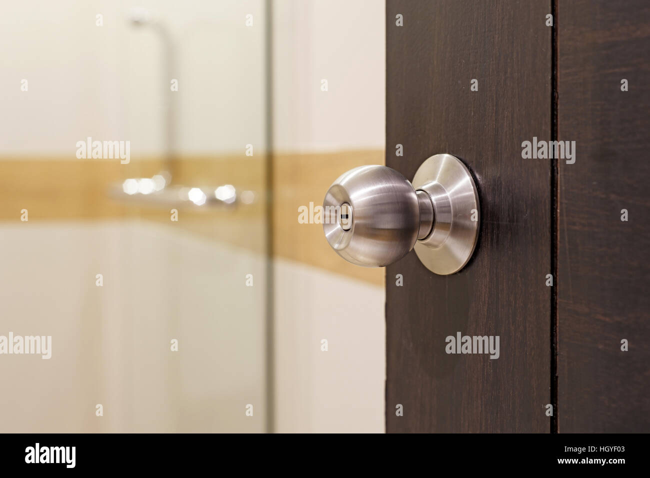 closeup of stainless doorknob on wooden door Stock Photo
