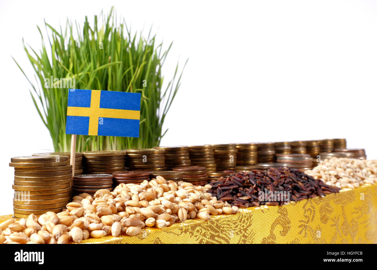 Sweden flag waving with stack of money coins and piles of wheat and rice seeds Stock Photo