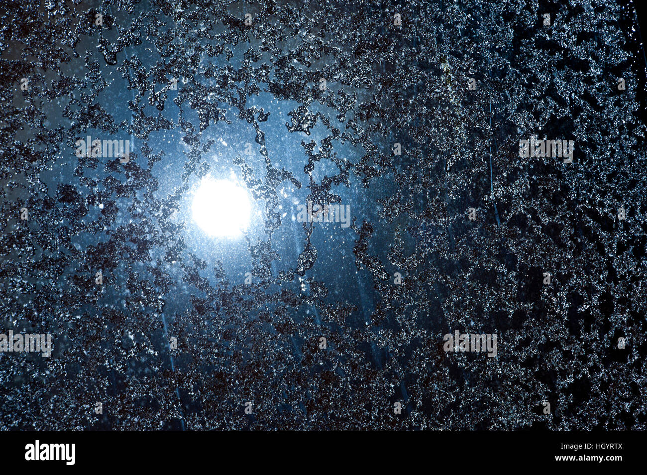 Builth Wells, UK. 14th January, 2017. A waning gibbous Wolf Moon - the January moon also known as the Old Moon -  is seen just after midnight shining eerily through icy snowflakes on a roof skylight in Builth Wells, UK. © Graham M. Lawrence/Alamy Live News Stock Photo