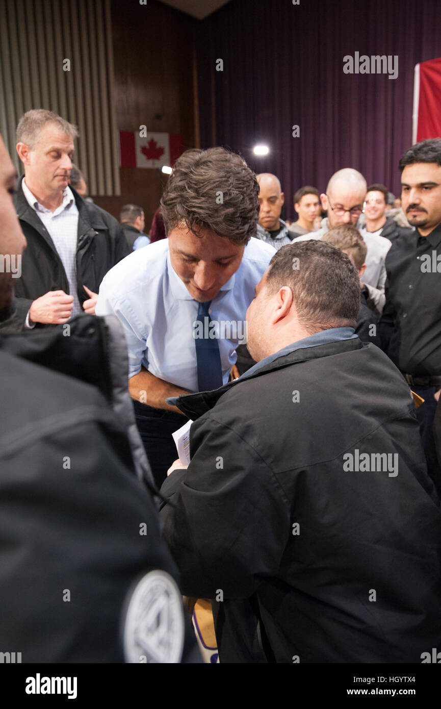 London, Canada, 13th January, 2017. Justin Trudeau, Prime Minister of Canada, talks to a recent Syrian refugee at the end of a town hall Q&A in the Alumni Hall of London's University of Western Ontario. London was one of his stops as part of his cross-country tour. Credit: Rubens Alarcon/Alamy Live News Stock Photo