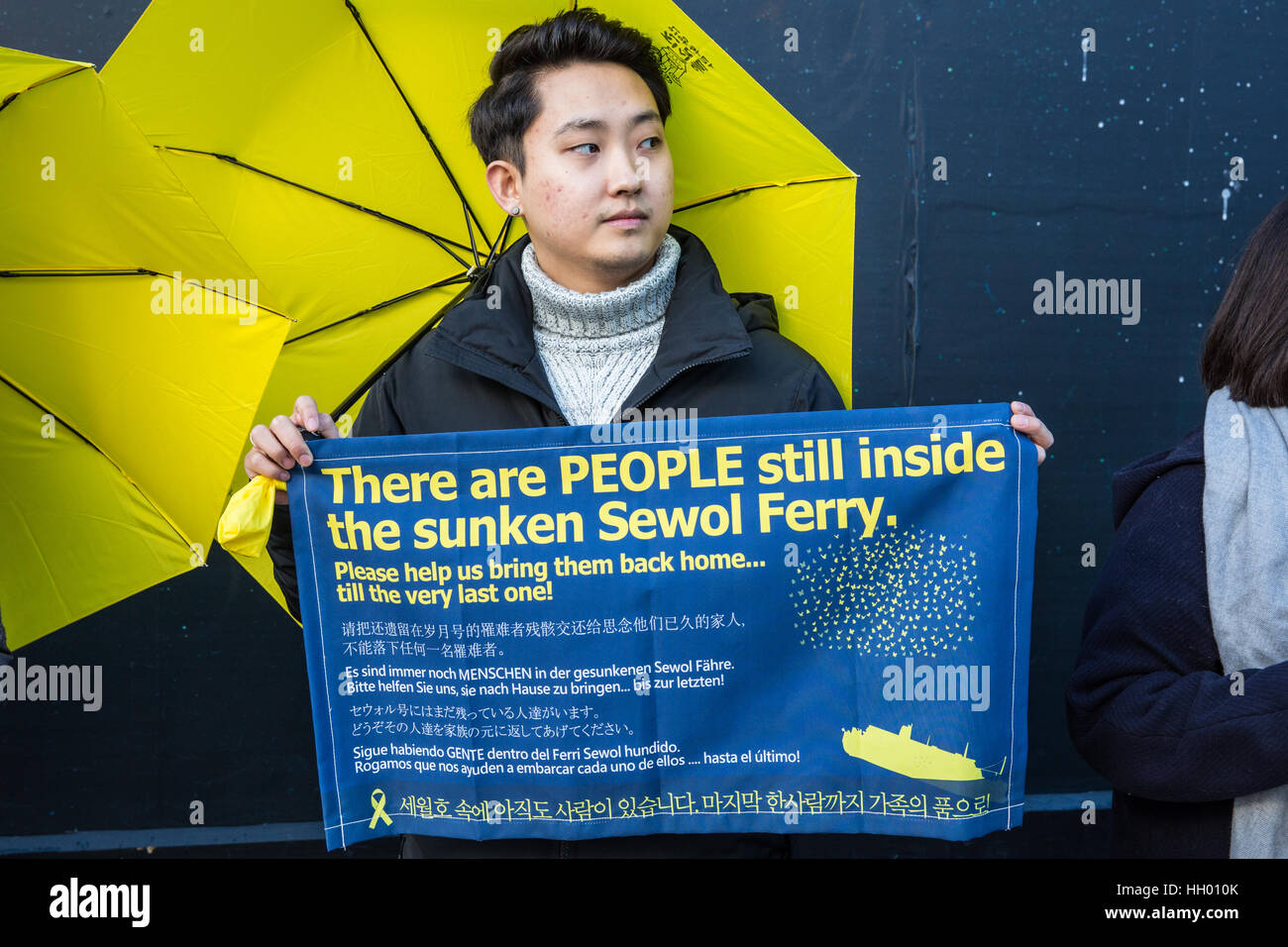 London, UK. 14th January, 2017. A member of the UK's Korean community holds a silent protest in Trafalgar Square to mark 1,000 days since the Sewol ferry disaster, to remember the victims and to demand that the Korean government not only raises the ferry without dismantling it to enable a thorough inquiry and recovery of all missing victims but also punishes those responsible and enacts anti-disaster regulations in London, UK. Credit: Mark Kerrison/Alamy Live News Stock Photo