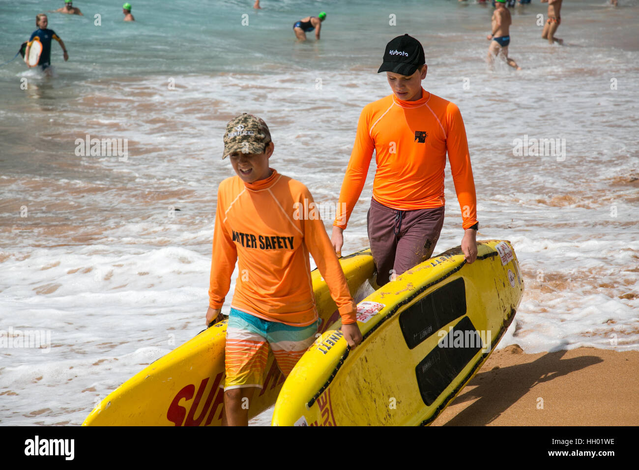 Sydney, Australia. 15th January 2017. Sunday 15th January 2017. Avalon Beach Annual  Ocean Swim is the third stage in the Pittwater Ocean Swim Series, and consists of a 1km event and a 1.5km course. Surf Rescue staff, body masseurs and first aid personnel were on hand in Sydney, Australia. These two boys are carrying surfboards to the adult lifesavers on the beach. Credit: model10/Alamy Live News Stock Photo