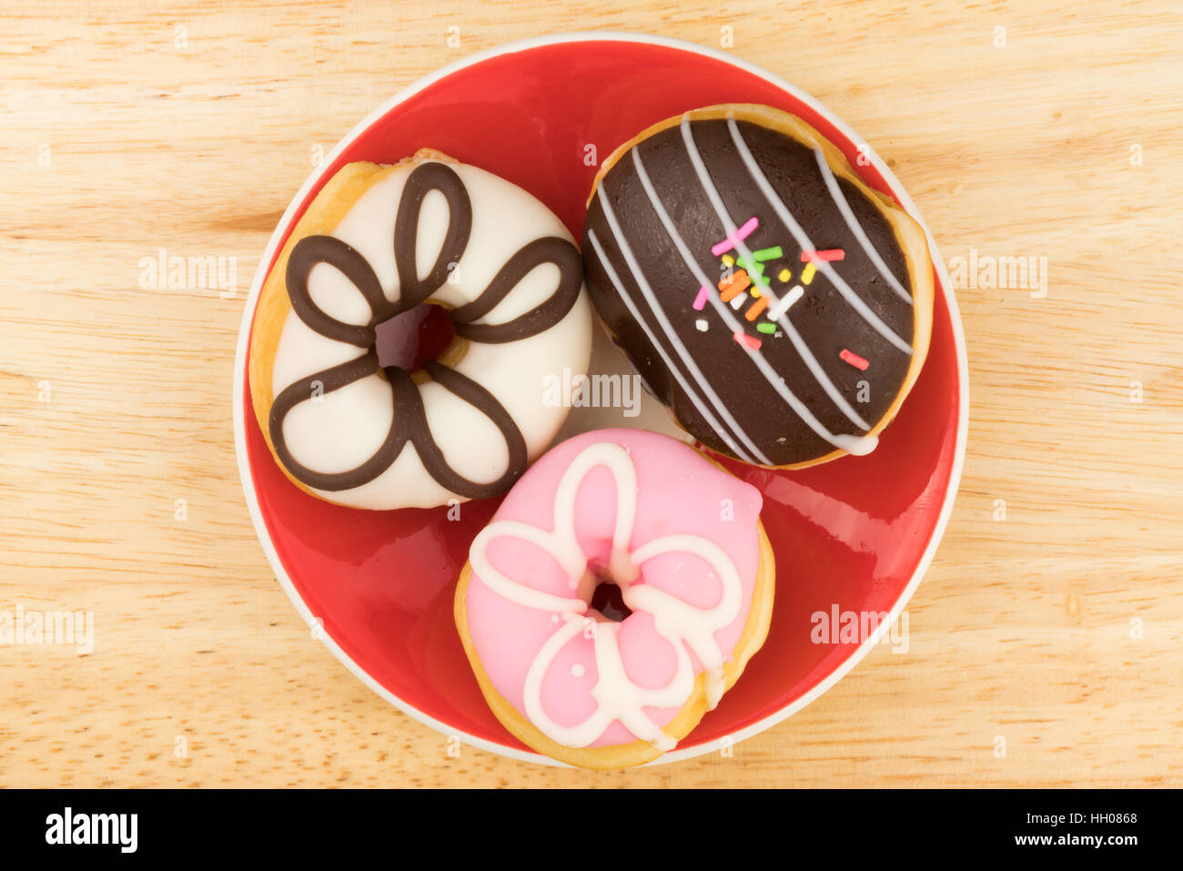 Tasty doughnuts in red plate on wooden board Stock Photo