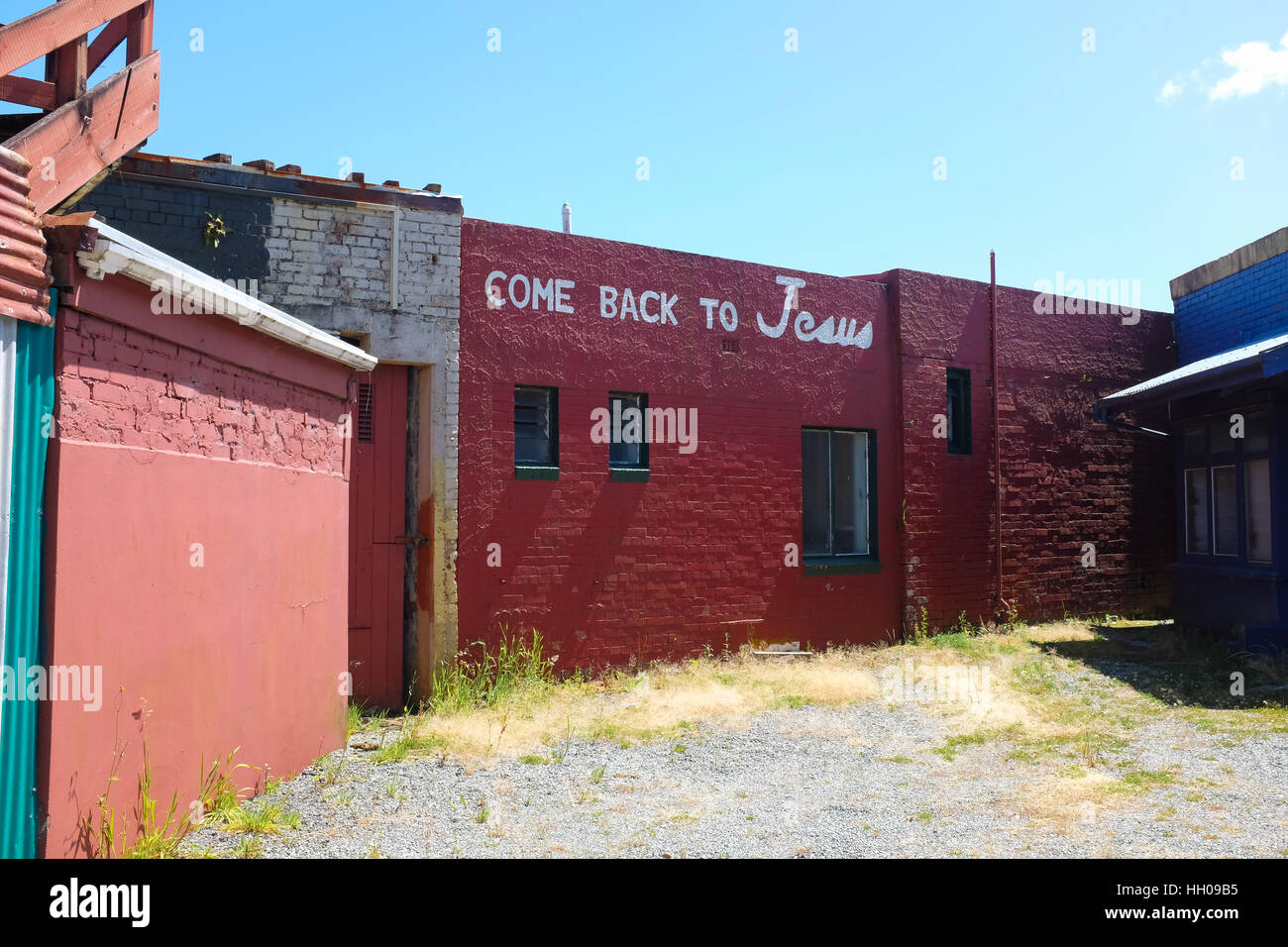 'Come back to Jesus' written on the side of a building in Greymouth, New Zealand. Stock Photo