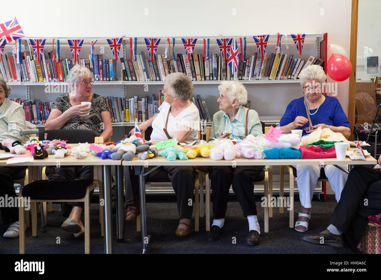 Elderly women selling knitwear during a party celebrating the Queen Elizabeth II's Birthday at Barking Community Centre . Stock Photo