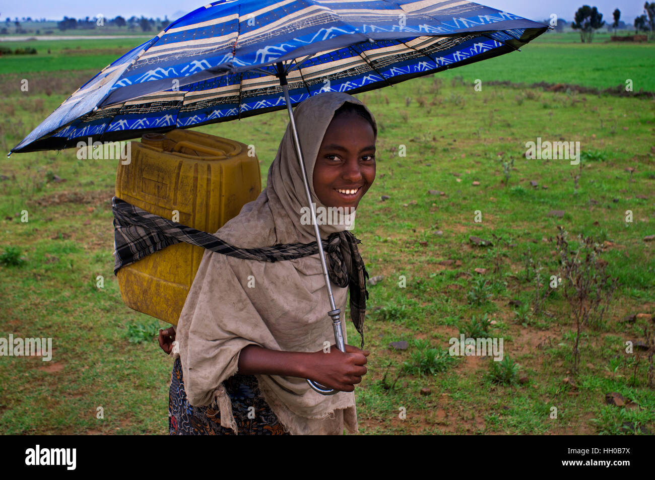 Gheralta mountains, near Hawzen, Eastern Tigray, Ethiopia. A girl carries the water that has gone to pick up a nearby well in the mountains of Gheralt Stock Photo