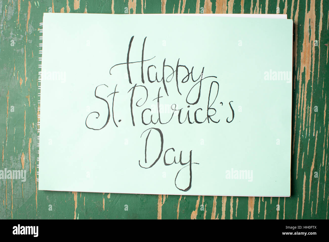 Happy St Patrick day calligraphy card on green paper Stock Photo