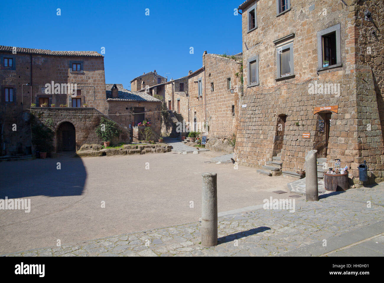 Civita di Bagnoregio, Italy - March 17, 2014: town's main square during the morning. Every building has become a little gastronomy shop, pub or restau Stock Photo