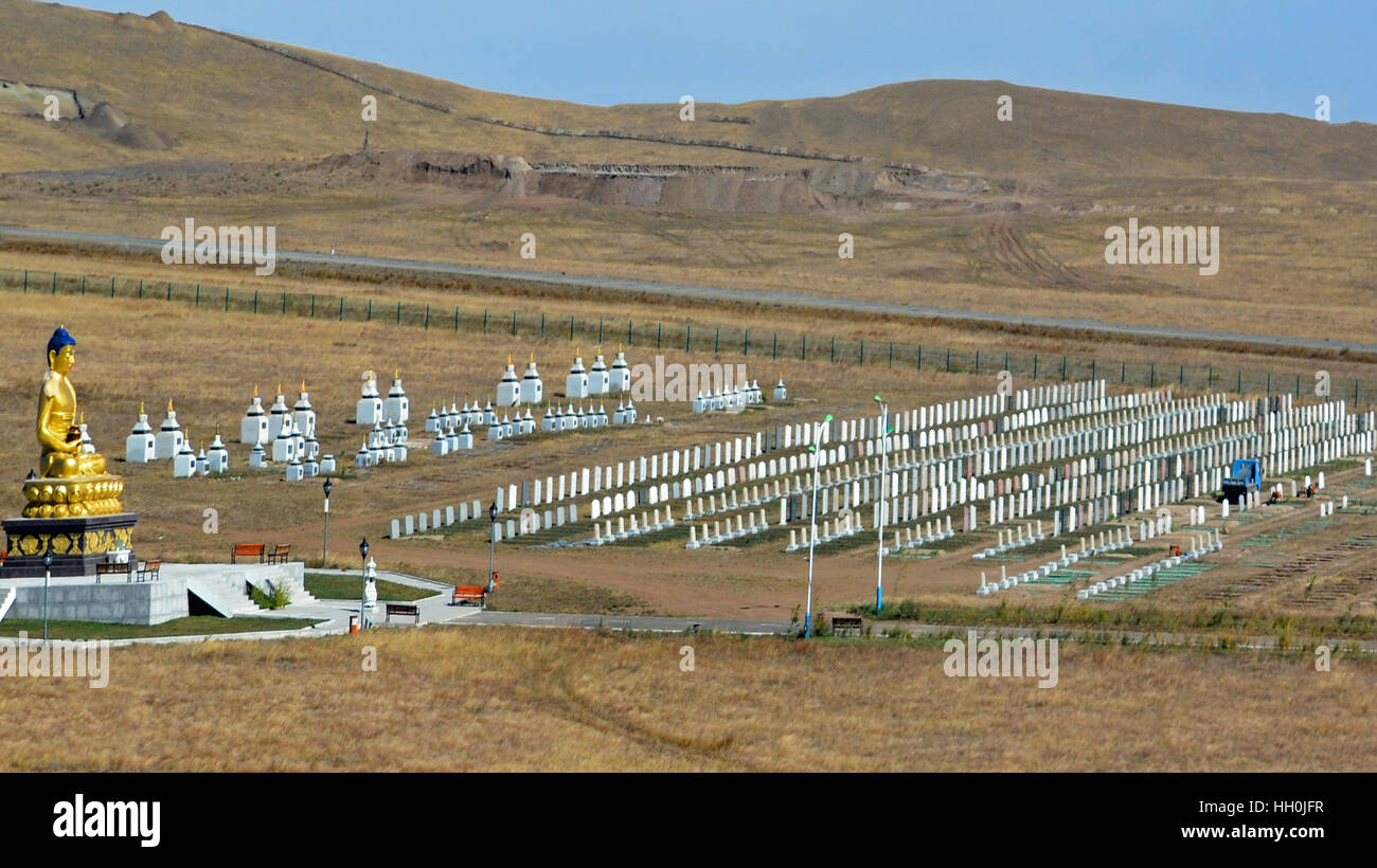 Mongolian cemetery on the steppe travelling on the Trans Siberian Railway. Large gold Buddha overlooks. Stock Photo
