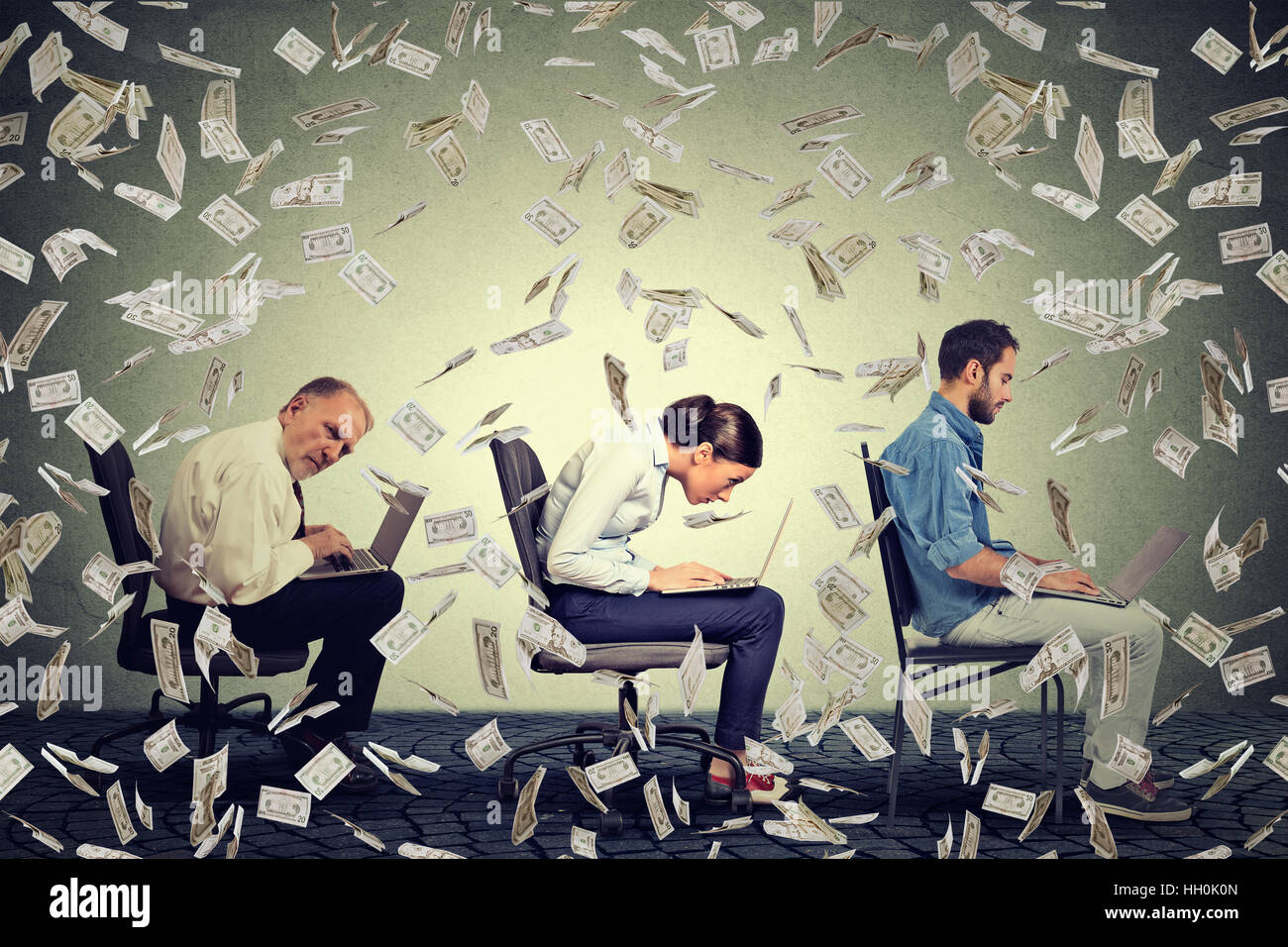 Company employees men woman sitting on chair working on laptops making money under dollar rain. Successful Internet business Stock Photo