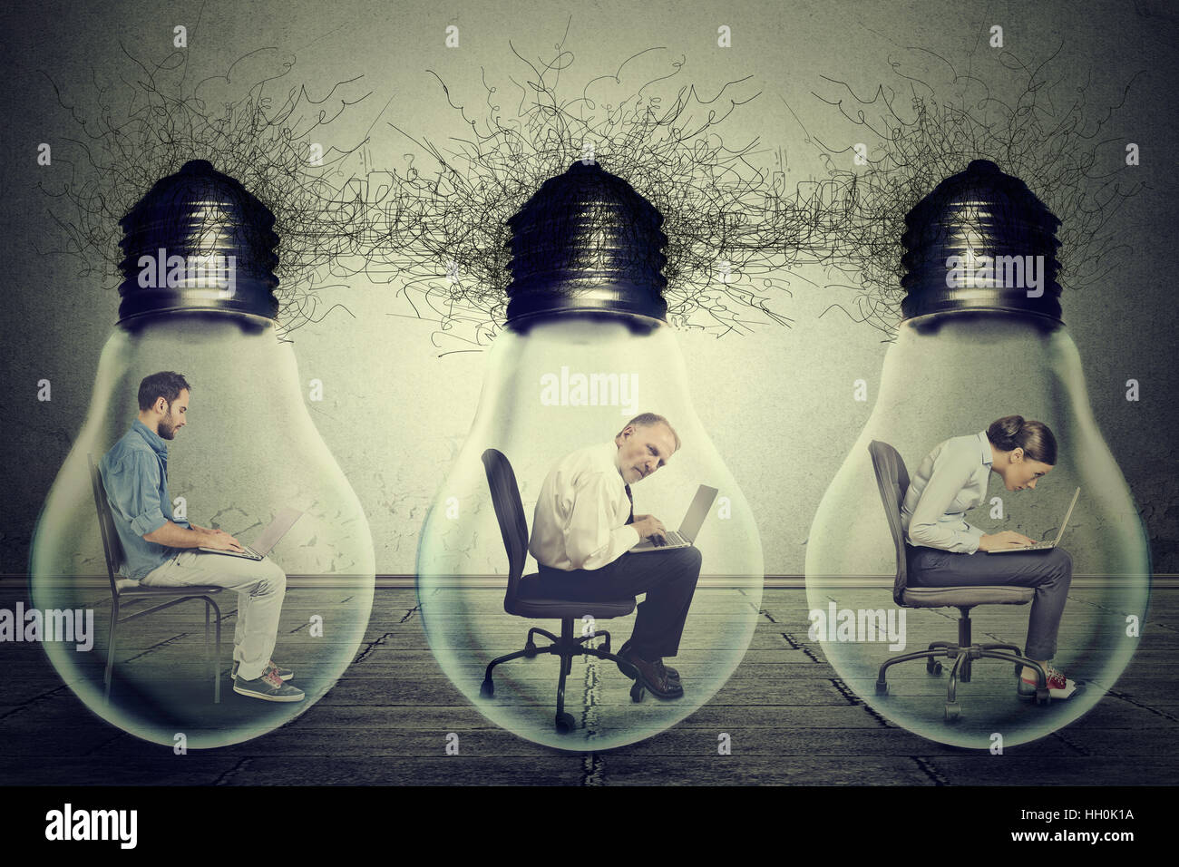 company employees sitting in row inside electric lamp light bulb using laptop isolated on gray background. Idea exchange network Stock Photo