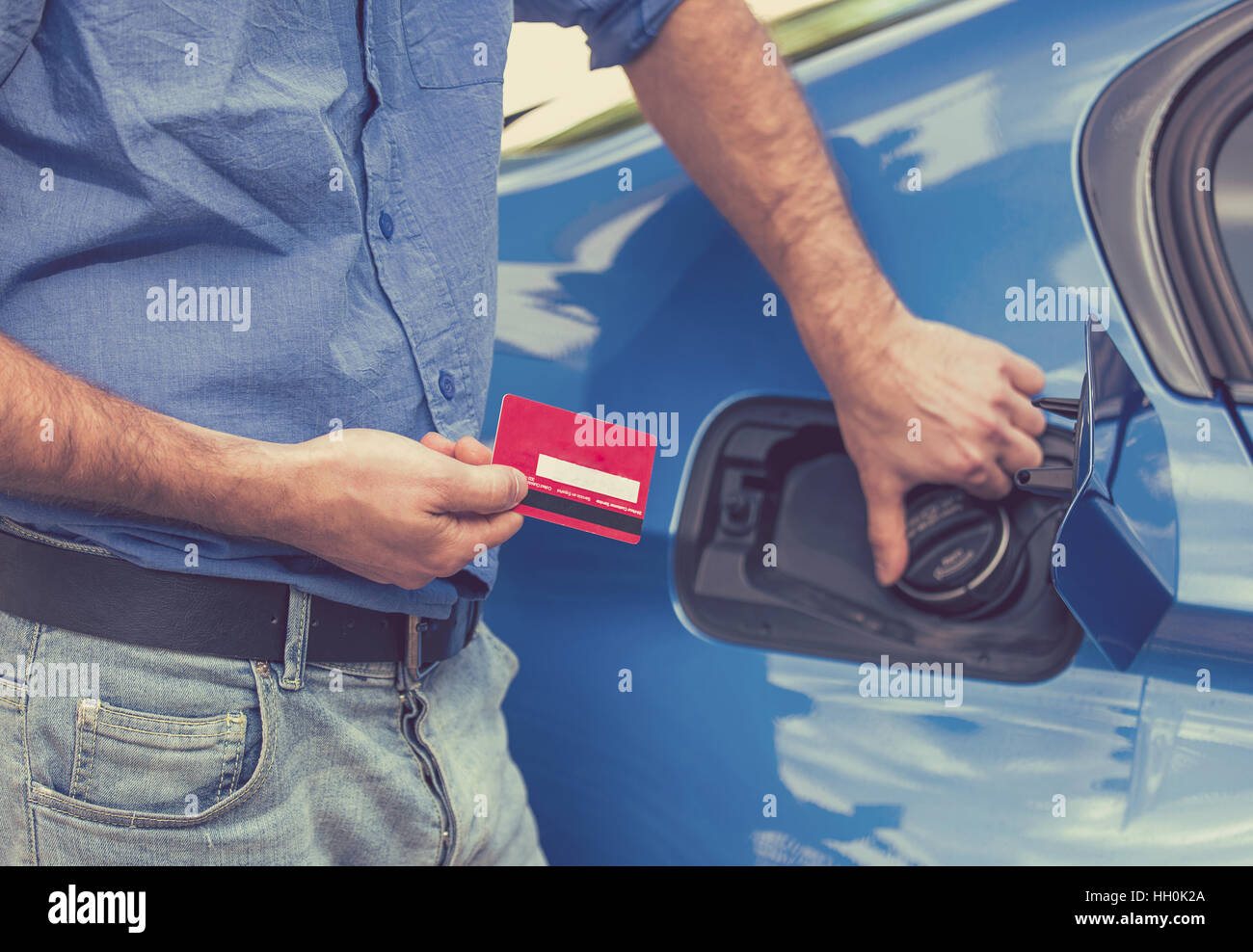Man With Credit Card Opening Fuel Tank Of His New Car Stock Photo