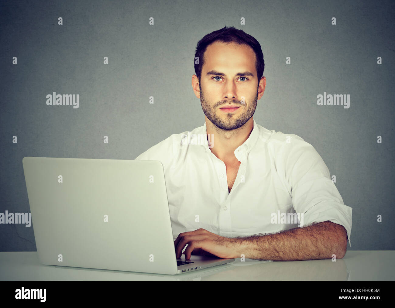 Smiling young business man using a laptop Stock Photo