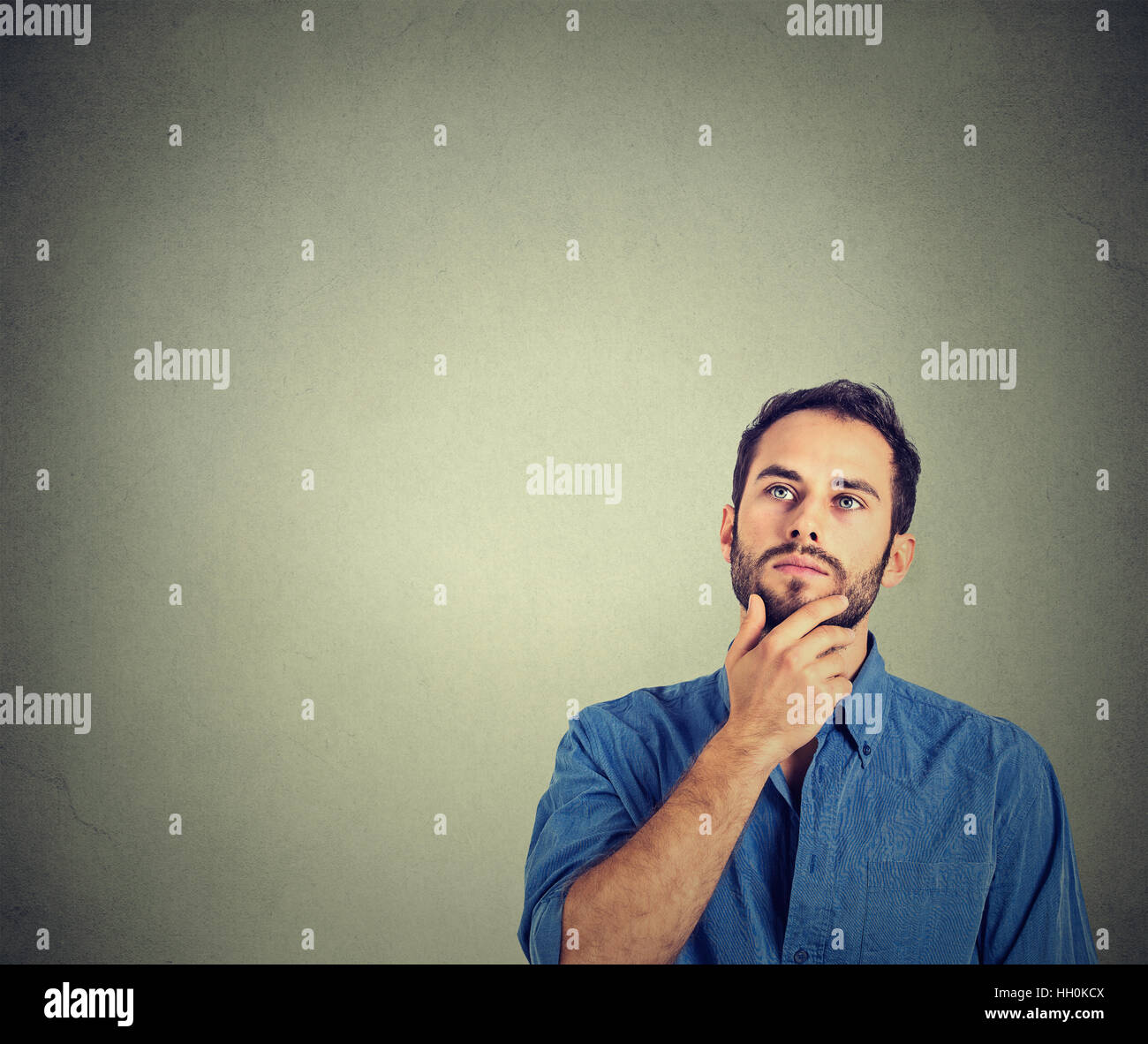 man thinking looking up isolated on gray background with copy space. Human face expressions, emotions, feelings, perception Stock Photo
