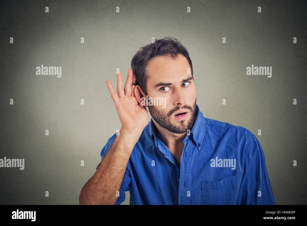 Portrait of handsome man secretly listening on private conversation. Human face, expression, emotion, body language Stock Photo