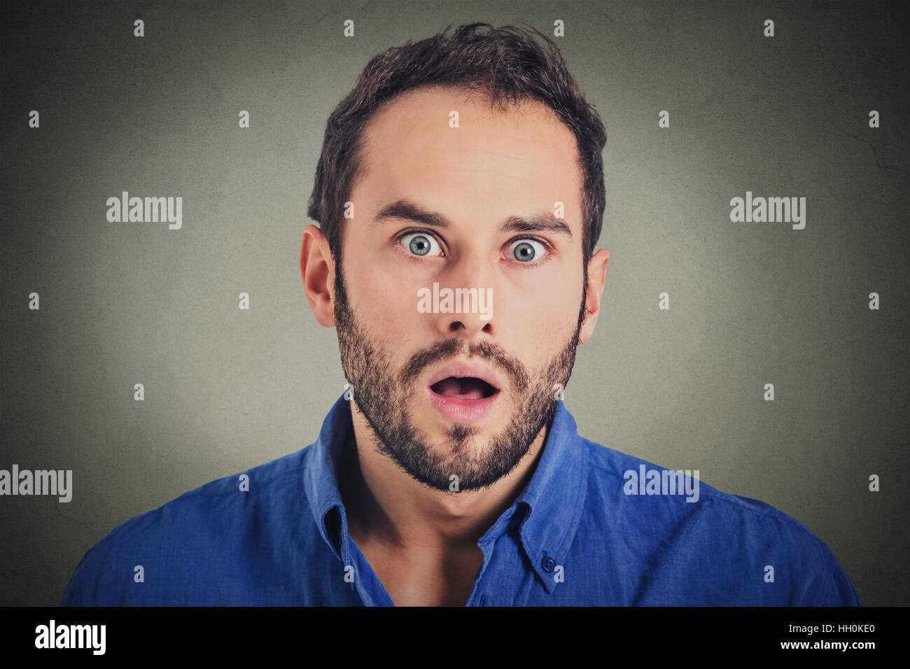 Portrait of young surprised emotional big eyes man with open mouth