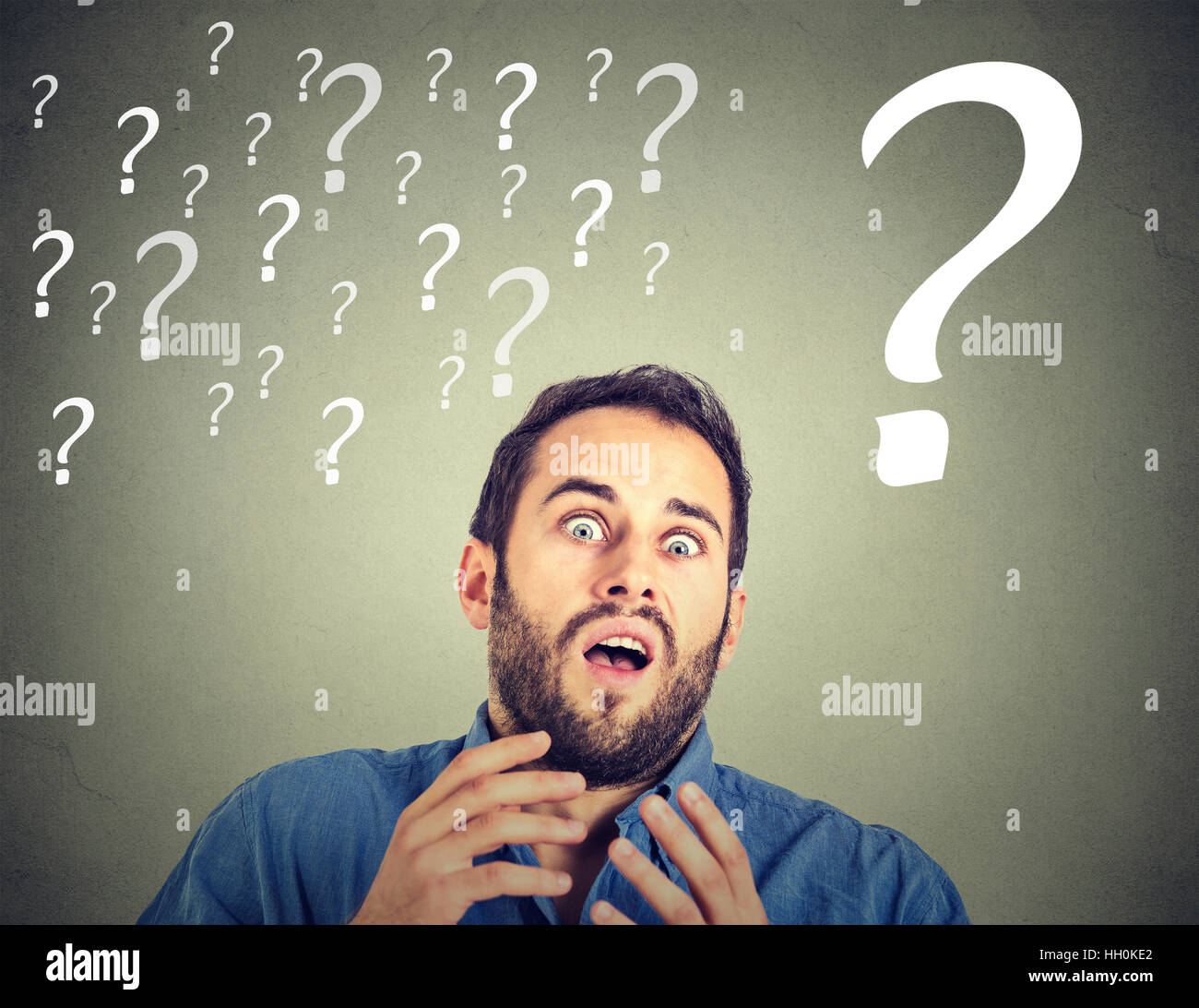 Surprised funny looking scared business man with many question marks ...