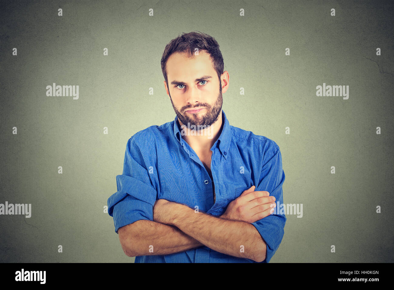 angry grumpy man looking very displeased isolated on gray wall background. Negative human emotions facial expression feelings Stock Photo