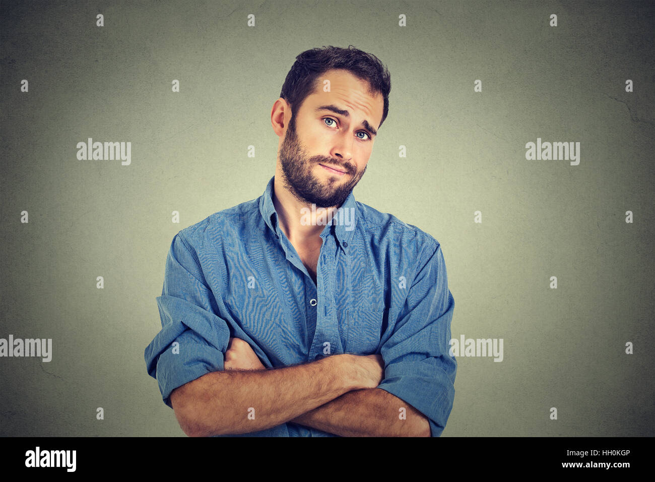 skeptical man looking suspicious, some disgust on face mixed with disapproval isolated gray background. Negative human emotion Stock Photo